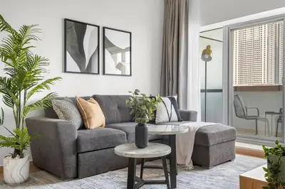 a living room with a gray couch and a table at Silkhaus Metro Close To Barsha Heights in Dubai