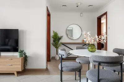 a dining room with a table and chairs and a mirror at Silkhaus Metro Close To Barsha Heights in Dubai
