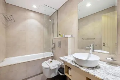 a bathroom with a sink and a toilet and a tub at 2BR High Floor Infinity Pool w/ Burj Khalifa view in Dubai