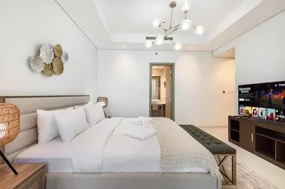 a bedroom with a bed and a flat screen tv at 2BR High Floor Infinity Pool w/ Burj Khalifa view in Dubai