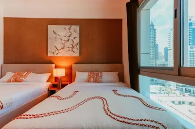 two beds in a room with a large window at Dubai Marina Delight: Spacious Retreat for Groups in Dubai
