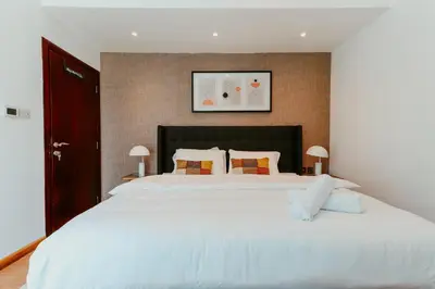 a bedroom with a large bed with white sheets at Dubai Marina Delight: Spacious Retreat for Groups in Dubai