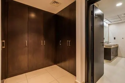 a bathroom with wooden cabinets and a sink at Balqis Residences I Spacious and Modern 4BDR I Palm Jumeirah in Dubai