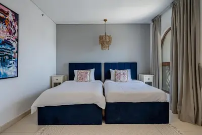a bedroom with two beds and a chandelier at Balqis Residences I Spacious and Modern 4BDR I Palm Jumeirah in Dubai