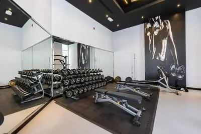 a gym with a bunch of bikes and weights at Exclusive 2BR Apartment in Madison Residency - Close to Dubai Internet City Metro Station in Dubai