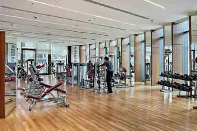 a gym with treadmills and exercise equipment in a building at Luxury 1BR Skyline & Sea Views Walk to Dubai Mall & Burj Khalifa in Dubai
