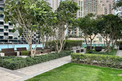 a park with benches and trees in a city at Luxury 1BR Skyline & Sea Views Walk to Dubai Mall & Burj Khalifa in Dubai