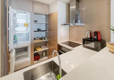 a kitchen with a sink and an open refrigerator at Savis Homes - Damac Paramount Tower A 1BR Ultimate Luxury and Glam Escape in Dubai