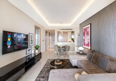 a living room with a couch and a tv at Savis Homes - Damac Paramount Tower A 1BR Ultimate Luxury and Glam Escape in Dubai
