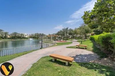 two benches in a park next to a river at Vogue Springs Emirates Living near The Springs Souk, JBR, Marina, Mall of the Emirates, Spacious Villa with Garden and access to Lake and all Amenities in the Community in Dubai