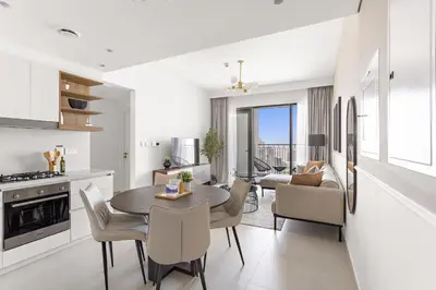 a kitchen and living room with a table and chairs at Silkhaus High Floor Luxury 1BDR in New Tower in Dubai