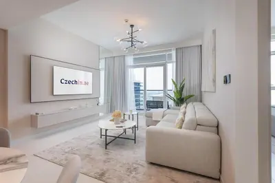 a living room with a couch and a tv at Czechin * Brand New * BeachFront * Palm View * High Floor in Dubai