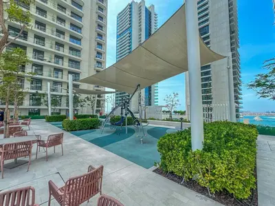 a patio with tables and chairs and a large umbrella at Czechin * Brand New * BeachFront * Palm View * High Floor in Dubai