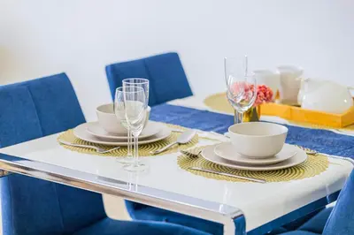 a dining table with plates and glasses on it at Sound of the Waves in JBR by Lagom in Dubai