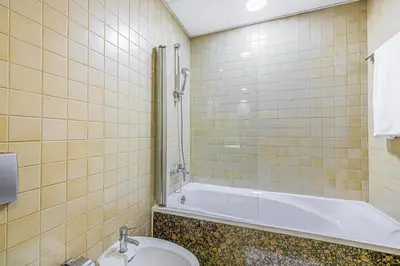 a bathroom with a tub and a toilet and a sink at Sound of the Waves in JBR by Lagom in Dubai