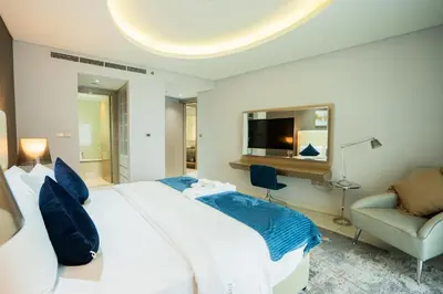 a bedroom with a large white bed and a couch at Luxe 2BR Haven with Spectacular Burj Khalifa & Dubai Frame Views By ĀYA Boutique in Dubai