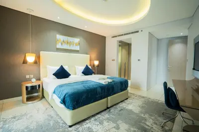 a bedroom with a large bed with a blue blanket at Luxe 2BR Haven with Spectacular Burj Khalifa & Dubai Frame Views By ĀYA Boutique in Dubai