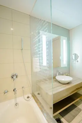 a bathroom with a tub and a sink and a mirror at Luxe 2BR Haven with Spectacular Burj Khalifa & Dubai Frame Views By ĀYA Boutique in Dubai