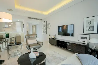 a living room with a couch and a tv and a table at Luxe 2BR Haven with Spectacular Burj Khalifa & Dubai Frame Views By ĀYA Boutique in Dubai