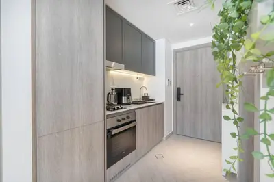 a kitchen with a stove top oven next to a door at New Listing * Pool & Marina Skyline View * TOP Amenities in Dubai