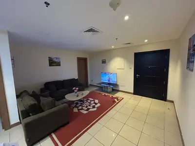 a living room with a couch and a table and a tv at luxury master room available in sulafa tower marina in Dubai