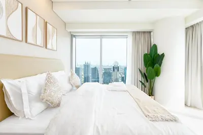 a bedroom with a white bed and a large window at The Star in Dubai