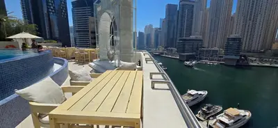 a balcony with a table and boats in the water at The Star in Dubai