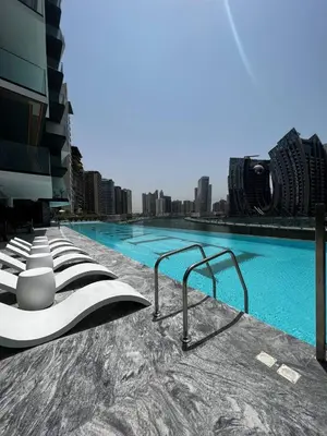 a large swimming pool with blue water and buildings at Dubai Skyline Retreat with Burj Khalifa View in Dubai