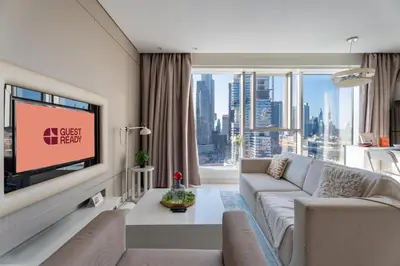 a living room with a couch and a tv at GuestReady - Maison Vogue Studio Business Bay in Dubai