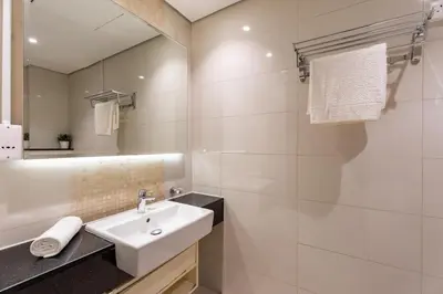 a white bathroom with a sink and a mirror at GuestReady - Maison Vogue Studio Business Bay in Dubai
