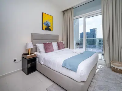 a bedroom with a large bed and a large window at 1 Bedroom Business Bay Bliss with a Canal View in Dubai