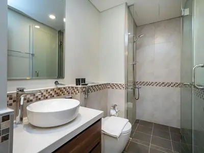 a bathroom with a white sink and a shower at 1 Bedroom Business Bay Bliss with a Canal View in Dubai