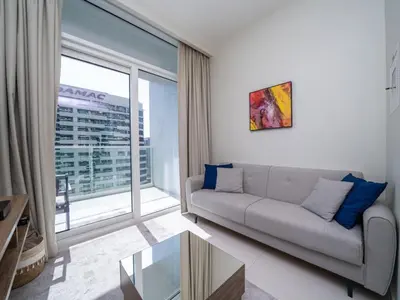 a living room with a couch and a large window at 1 Bedroom Business Bay Bliss with a Canal View in Dubai