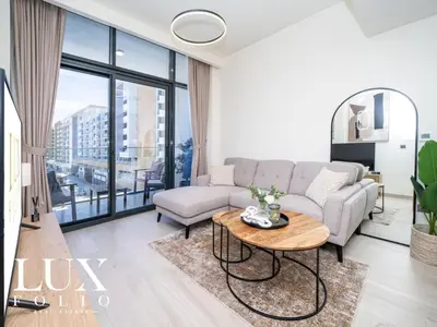 a living room with a couch and a table at Chic 1 Bed Meydan Escape with a Pool View in Dubai