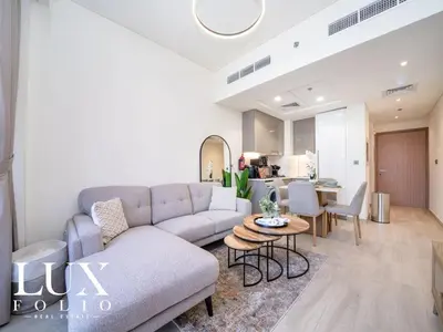 a living room with a couch and a table at Chic 1 Bed Meydan Escape with a Pool View in Dubai