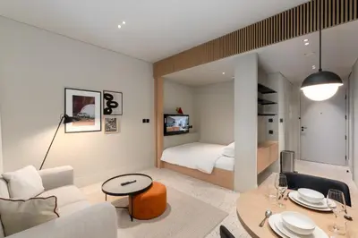 a living room with a couch and a table and a bed at Upside Living, Business Bay Dubai - Mint Stay in Dubai