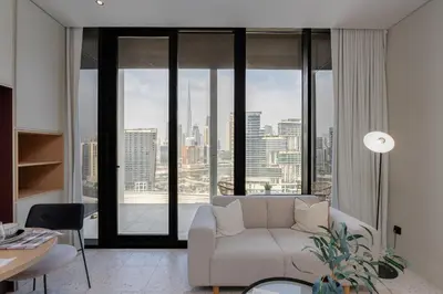 a living room with a couch and a large window at Upside Living, Burj Khalifa View, Business Bay - Mint Stay in Dubai