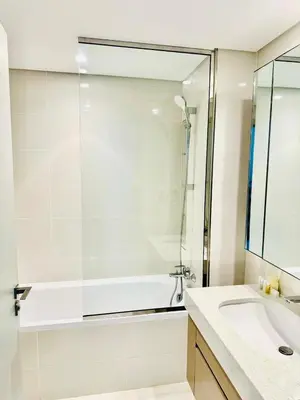 a white bathroom with a tub and a sink at Modern 1BR Oasis in Beach Isle with Beach Access in Dubai