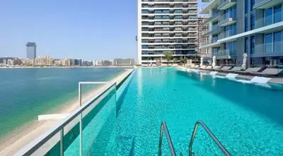a large swimming pool next to a large building at Modern 1BR Oasis in Beach Isle with Beach Access in Dubai