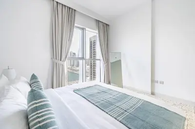 a bedroom with a white bed with a large window at Modern 1BR Oasis in Beach Isle with Beach Access in Dubai