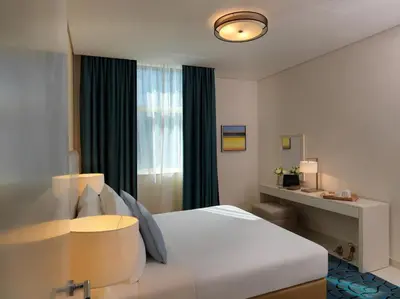 a hotel room with a bed and a window at DAMAC Maison Cour Jardin in Dubai