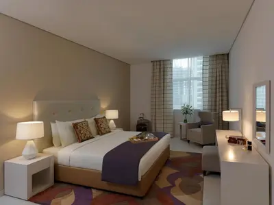 a bedroom with a large bed and a living room at DAMAC Maison Cour Jardin in Dubai