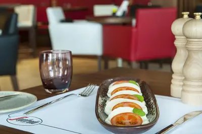 a bowl of sushi on a table with a glass at DAMAC Maison Cour Jardin in Dubai