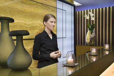 a woman standing in front of a table with candles at DAMAC Maison Cour Jardin in Dubai