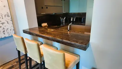 a kitchen with a counter with four chairs and a sink at Damac Heights by Fendi in Dubai