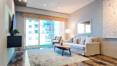 a living room with a couch and a table at Damac Heights by Fendi in Dubai