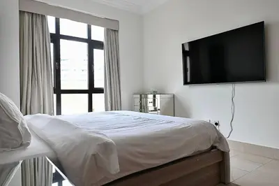 a bedroom with a bed with a flat screen tv on the wall at Lux Souk al Bahar Downtown Dubai 1 bedroom flat - Steps to Dubai Mall in Dubai