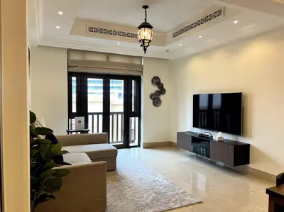 a living room with a couch and a flat screen tv at Lux Souk al Bahar Downtown Dubai 1 bedroom flat - Steps to Dubai Mall in Dubai
