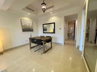 a dining room with a table and chairs on a tile floor at Lux Souk al Bahar Downtown Dubai 1 bedroom flat - Steps to Dubai Mall in Dubai