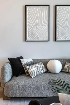 a living room with a couch with two pictures on the wall at The Smart Concierge - La Rive Port De Lamer in Dubai